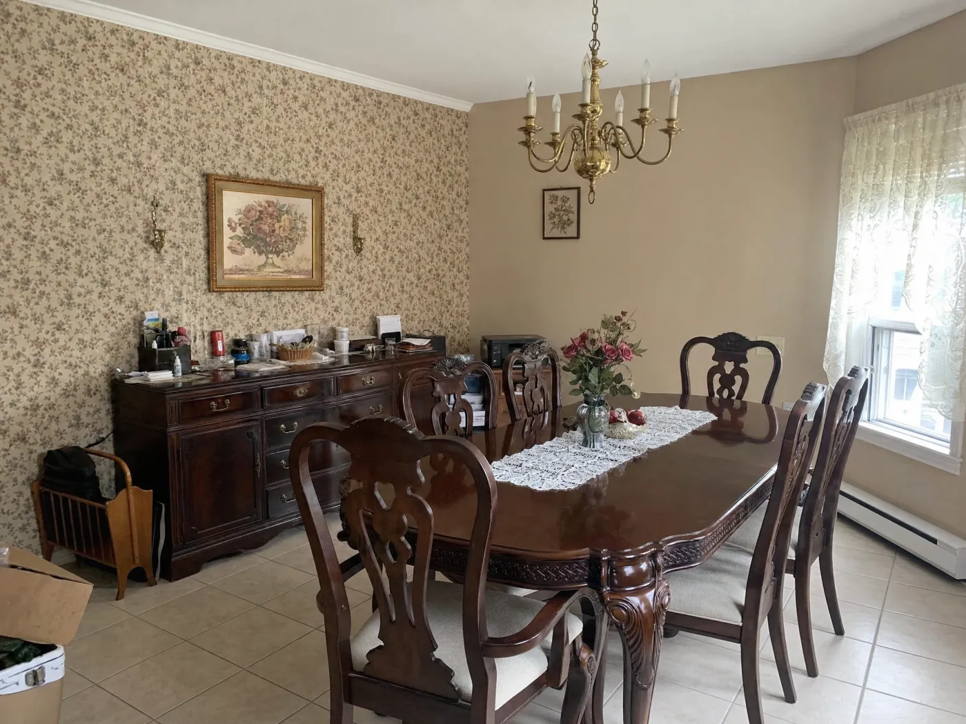 Dated dining room with heavy dark furniture and floral wallpaper before redesign